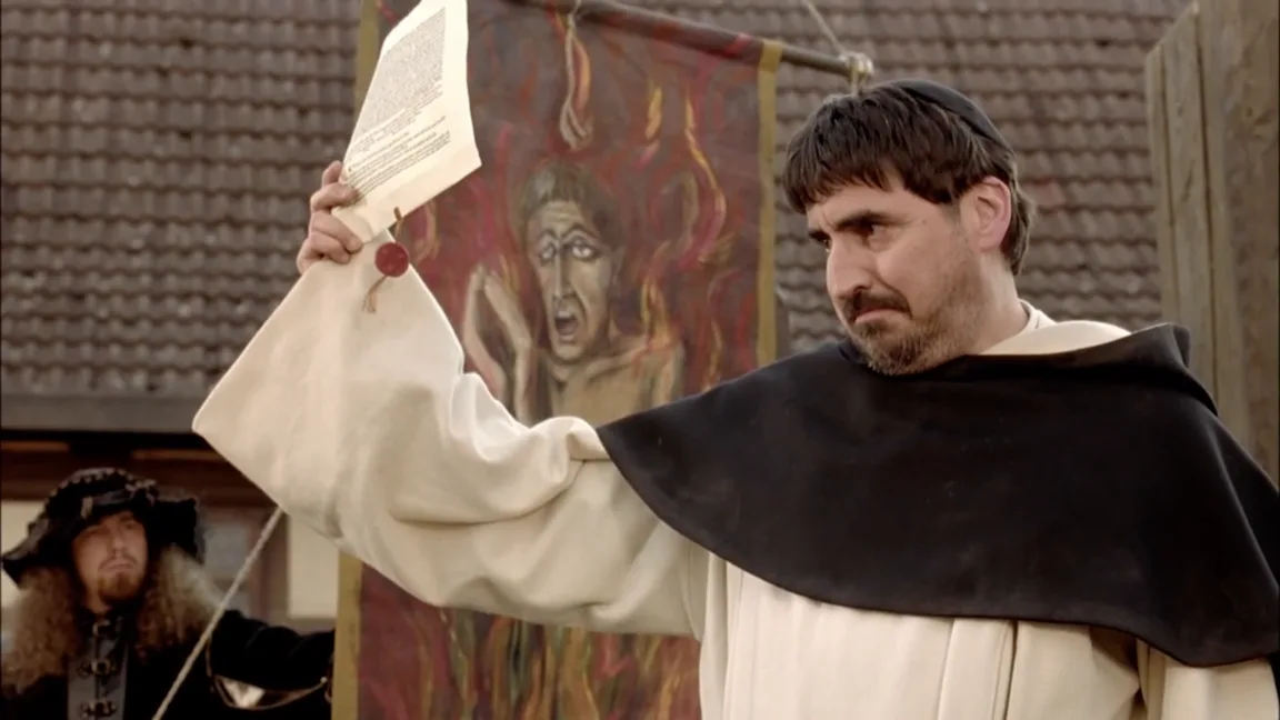 Johann Tetzel, in a friar’s habit, holds up a sealed indulgence beside a painted banner of a soul burning in purgatory.