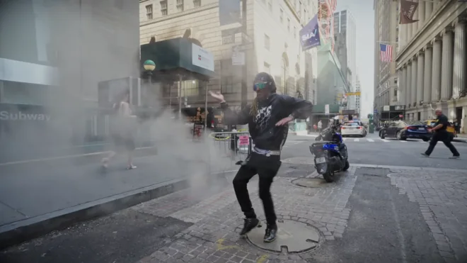 A dancer mid-step on a Wall Street sidewalk, steam rising from a vent behind him.